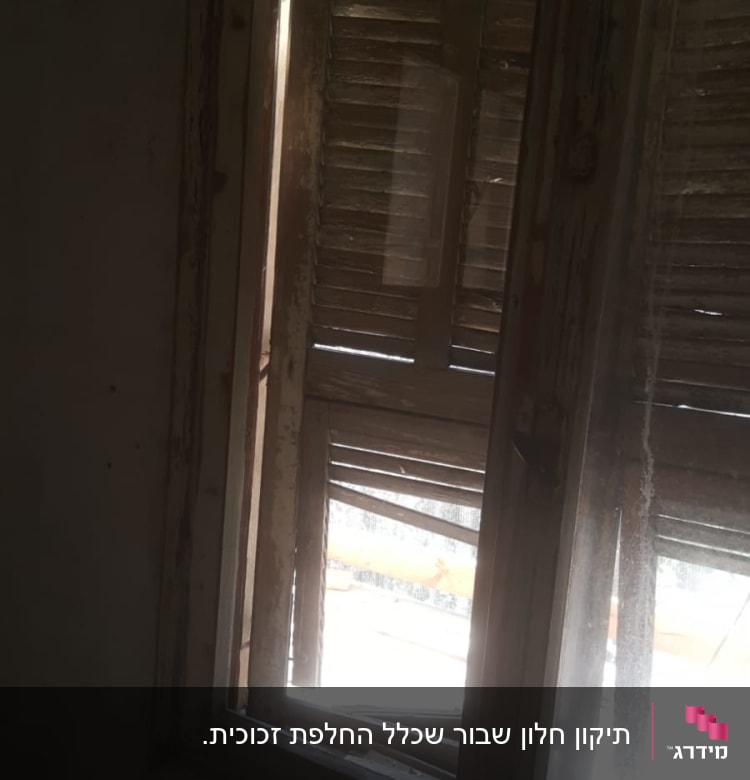 חלון עם זכוכית מלוכלכת ותריסים ישנים